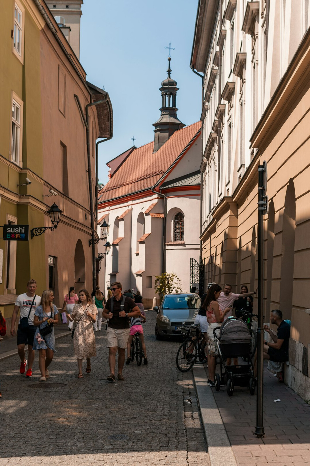 Narrow street in a small Polish town with residents walking