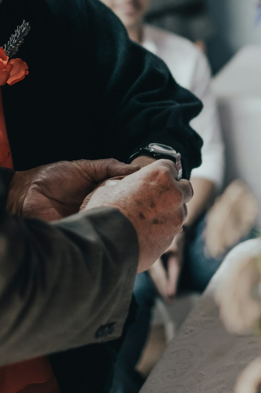 Hands of an elderly man resting near an audio recorder during an interview