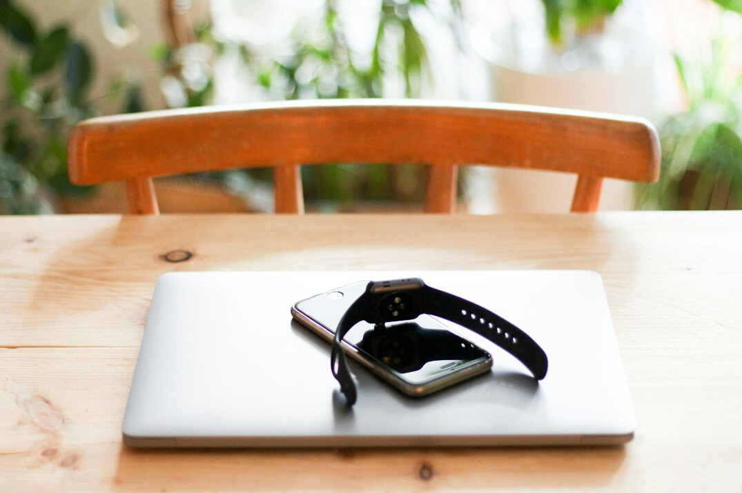 Audio recorder and open notebook on a wooden table during an interview